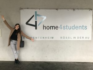 Ambassadorin Sara vor dem home4students Eingangs-Schild