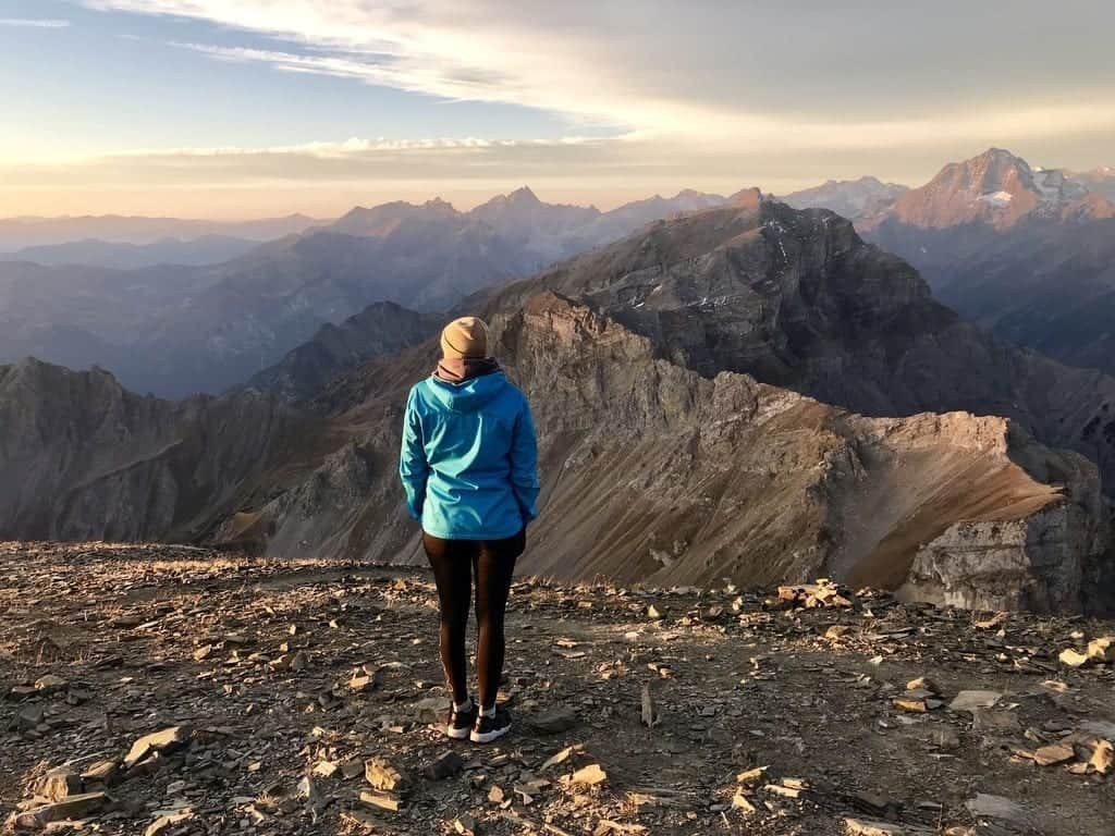 Sara steht vor einer atemberaubenden Berglandschaft