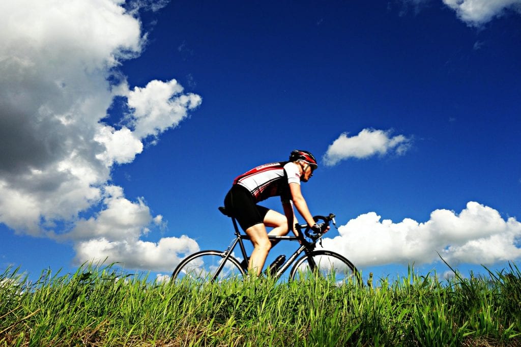 Radfahrer, Wolken und ein blauer Himmel