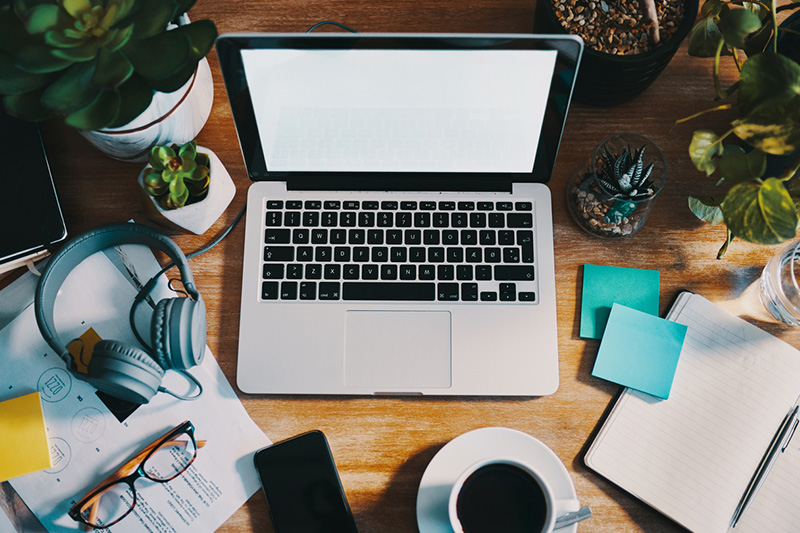 Arbeitsplatz mit Laptop, Kaffeetasse & Papier