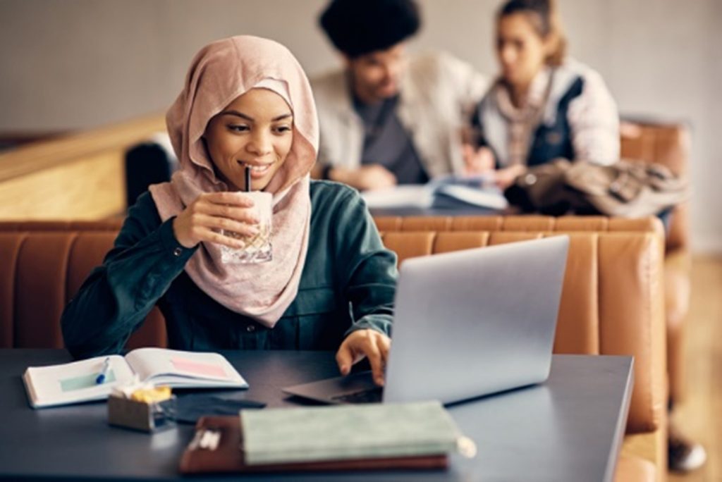 Studentin sitzt mit Laptop im Lerncafé in Salzburg