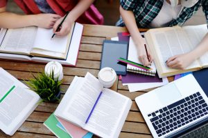 Gruppe lernt mit Büchern und Laptops im Lerncafé in Klagenfurt