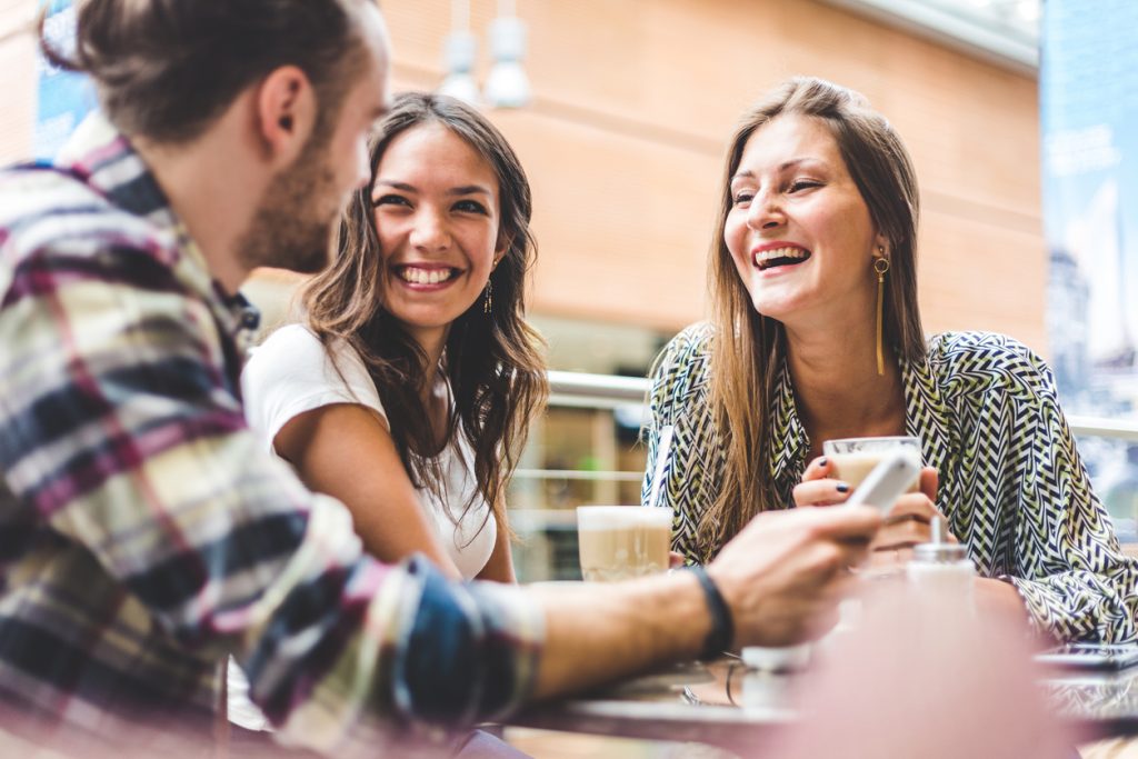 Freunde und Freundinnen trinken Kaffee und lachen